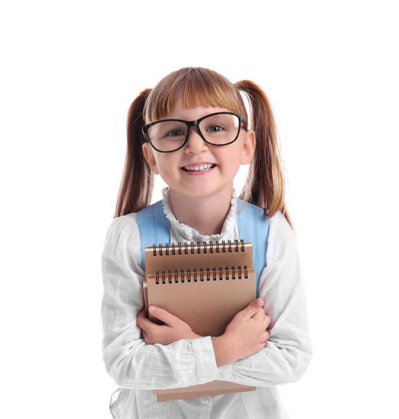 Schattige kleine schoolmeisje met notebooks op witte achtergrond - Foto, afbeelding