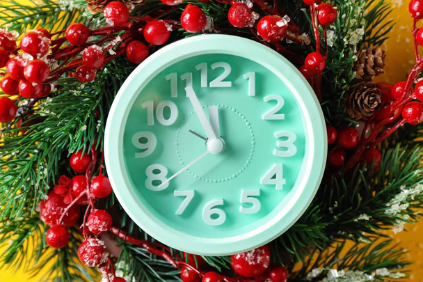 Alarm clock with fir wreath on color background, closeup. Christmas countdown - Photo, Image