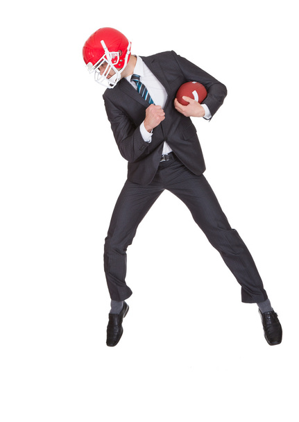 Competitive businessman playing american football - Фото, изображение