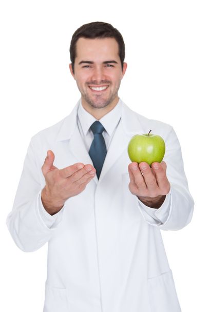 Male Doctor Holding Green Apple - Foto, afbeelding