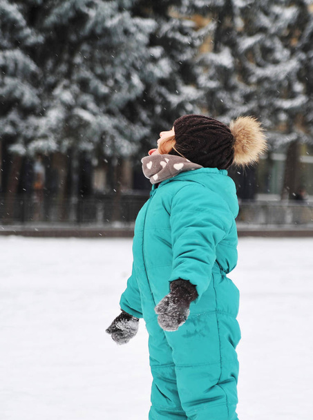 Menina bonito joga ao ar livre na neve
.  - Foto, Imagem