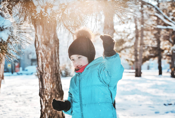 Мила дівчинка грає на відкритому повітрі в снігу
.  - Фото, зображення