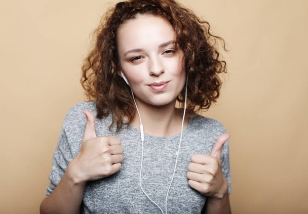 lifestyle and people concept:   Young curly woman with thumbs up - Valokuva, kuva
