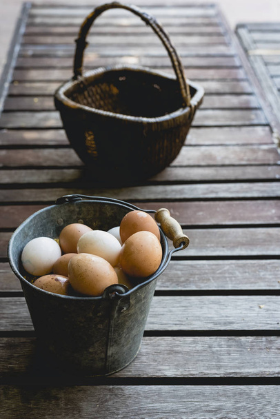 Ведро с куриными яйцами и плетеной корзиной
. - Фото, изображение