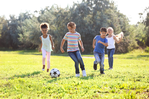 Милые маленькие дети играют в футбол на открытом воздухе
 - Фото, изображение