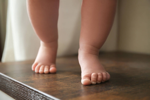 Legs of cute baby standing on table - Photo, Image