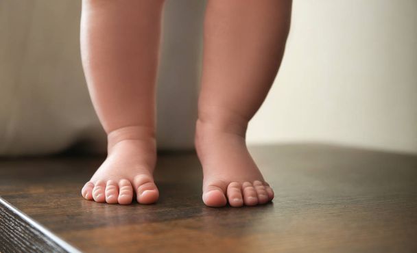 Legs of cute baby standing on table - Valokuva, kuva