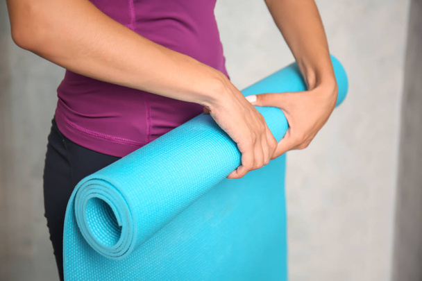 Yoga mat yakınındaki hafif duvar, closeup ile sportif kadın - Fotoğraf, Görsel