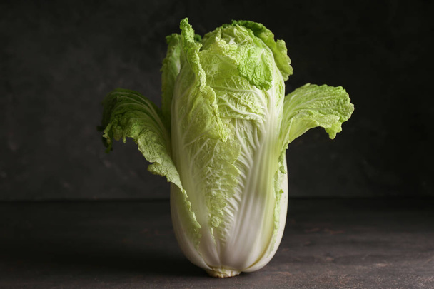 Fresh ripe cabbage on dark grey table - Фото, изображение