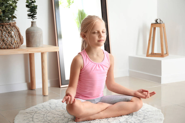 Little girl practicing yoga at home - Foto, Imagem