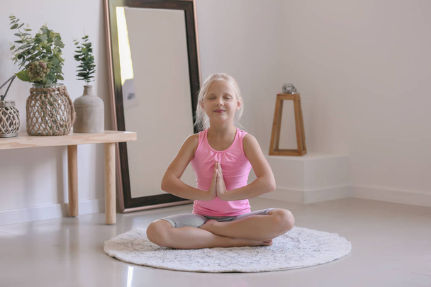 kleines Mädchen praktiziert Yoga zu Hause - Foto, Bild