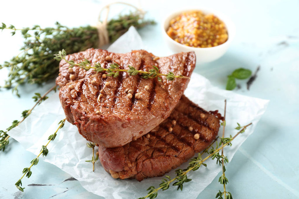 Délicieux steaks grillés au thym sur table lumineuse
 - Photo, image