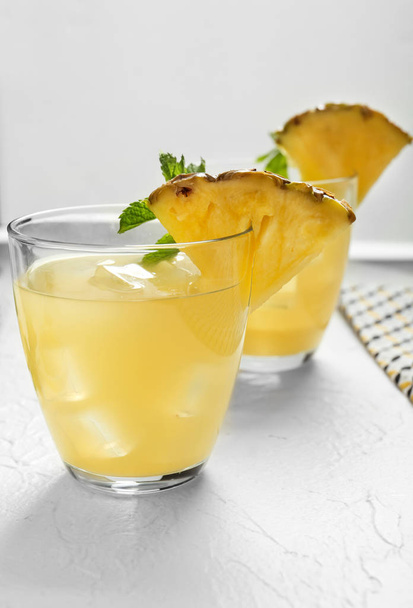 Bicchieri di cocktail di ananas saporito su tavolo bianco
 - Foto, immagini