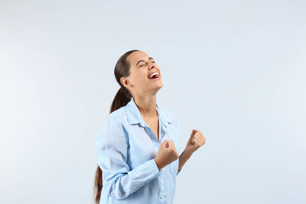 Happy successful young woman on light background - Photo, image
