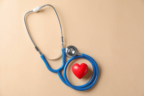 Medical stethoscope and red heart on light background. Cardiology concept - Photo, Image
