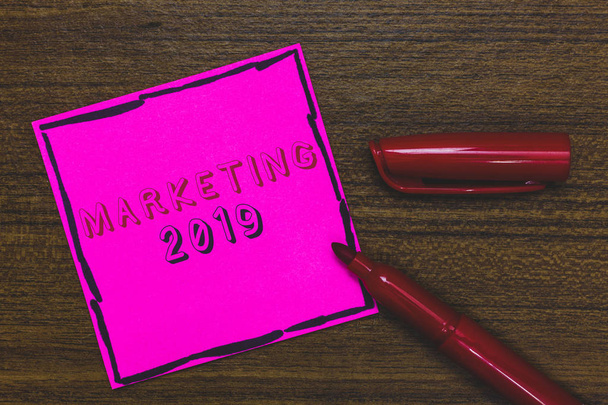 Handwriting text Marketing 2019. Concept meaning Commercial trends for 2019 New Year promotional event Pink Paper Important reminder Communicate ideas Marker Wooden background. - Photo, Image