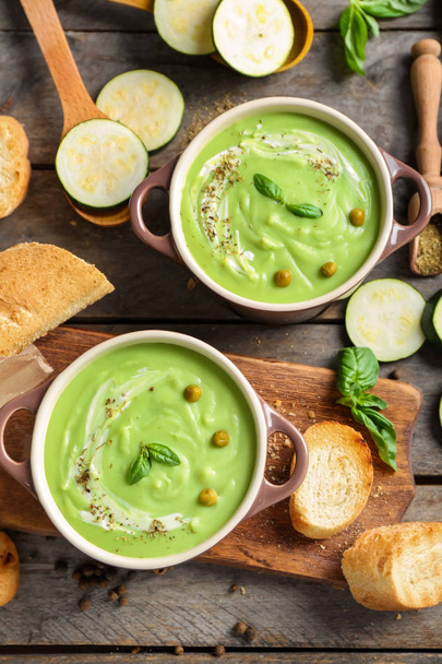 Tasty zucchini soup in saucepans on wooden table - Photo, Image