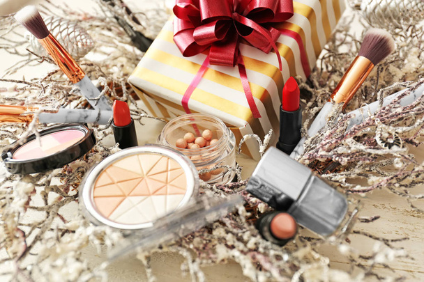 Set of decorative cosmetics with Christmas present and wreath on white wooden table - Fotografie, Obrázek