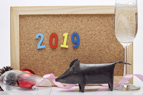 Feliz Ano Novo 2019 fita, bola de Natal, champanhe de vidro, cones de pinho, comemorar a placa de cortiça com a redação do número
 - Foto, Imagem