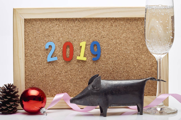 Bonne année 2019 ruban, boule de Noël, champagne en verre, cônes de pin, célébrer le panneau de liège avec la formulation numérique
 - Photo, image