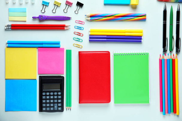 Композиція з різними шкільними канцелярськими приладдям та калькулятором на білому тлі
 - Фото, зображення