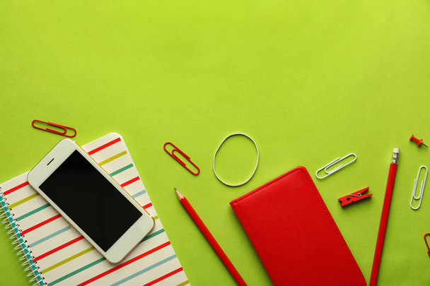 Composition with different school stationery and mobile phone on color background - Photo, Image