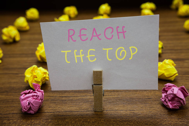 Handwriting text writing Reach The Top. Concept meaning Get Ahead Succeed Prosper Thrive for the Win Victory Clothespin holding white paper note crumpled papers several tries mistakes. - Photo, Image