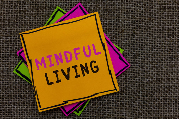 Text sign showing Mindful Living. Conceptual photo Fully aware and engaged on something Conscious and Sensible Paper notes Important reminders Communicate ideas messages Jute background. - Photo, Image
