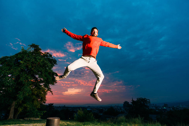 若い男が公園でジャンプしながらパルクールの練習 - 写真・画像