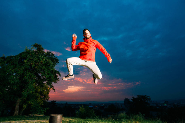 Retrato de cuerpo completo del hombre parkour saltando alto en el parque
 - Foto, Imagen