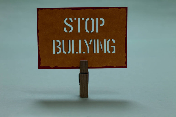 Text sign showing Stop Bullying. Conceptual photo Fight and Eliminate this Aggressive Unacceptable Behavior Clothespin holding orange paper important communicating message ideas. - Photo, Image