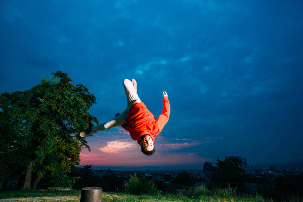Giovane uomo che pratica il parkour mentre salta nel parco
 - Foto, immagini