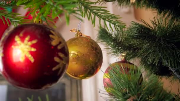 4k video of camra moving between branches of Christmas tree at living room - Video