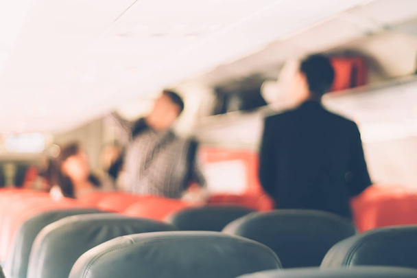 Rozmycie wewnątrz samolotu gospodarki klasy i podróżny podróże w czasie wakacji.  - Zdjęcie, obraz