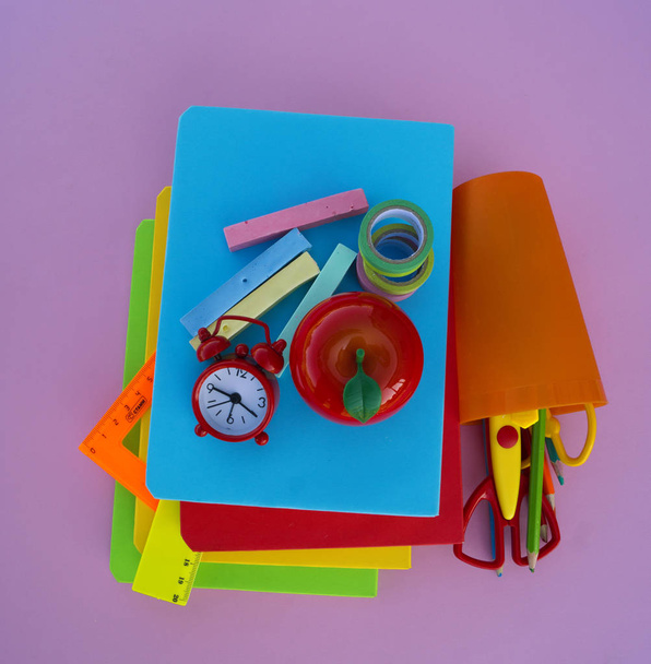The schoolboy's accessories lie on a pink table. Textbooks and office. Back to school. - Foto, immagini