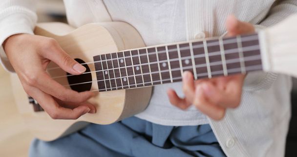 Woman play song on ukulele at home - Photo, Image