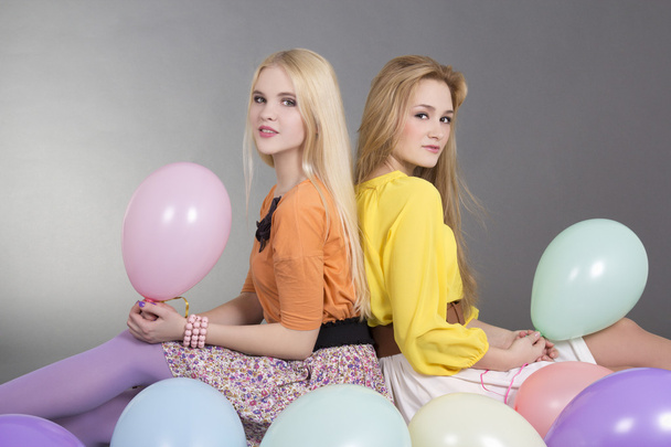 дві привабливі дівчата-підлітки з різнокольоровими повітряними кулями
 - Фото, зображення