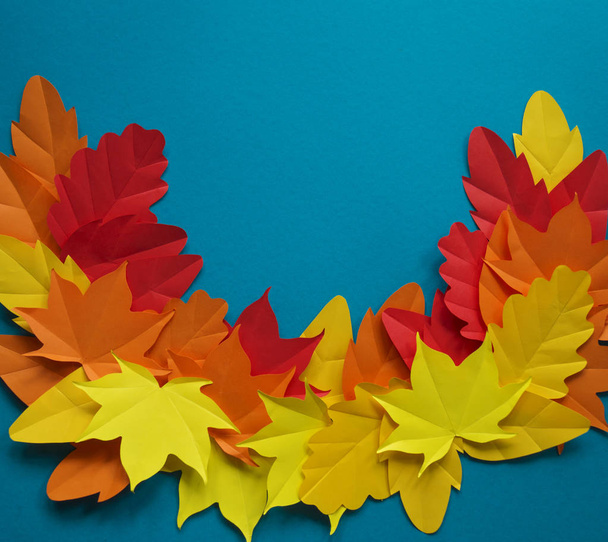 Leaves of paper fall red, orange, yellow leaf fall. Blue background. Handmade origami. - Foto, imagen