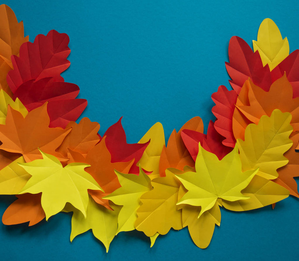 Leaves of paper fall red, orange, yellow leaf fall. Blue background. Handmade origami. - Foto, afbeelding