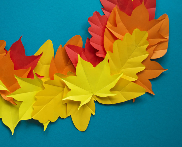 Leaves of paper fall red, orange, yellow leaf fall. Blue background. Handmade origami. - Photo, Image