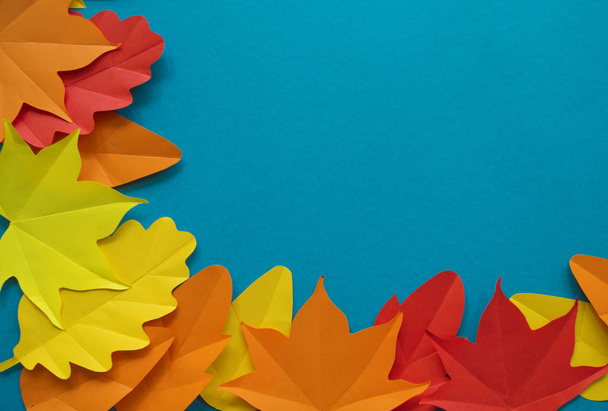 Leaves of paper fall red, orange, yellow leaf fall. Blue background. Handmade origami. - Fotoğraf, Görsel