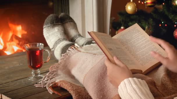 4k imagens de jovem relaxante com livro junto à lareira e beber vinho quente
 - Filmagem, Vídeo