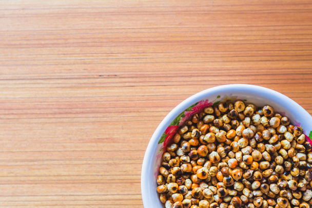 einer der beliebtesten Snacks aus nepal gebratenem Mais in einer Schüssel auf dem Holztisch. - Foto, Bild