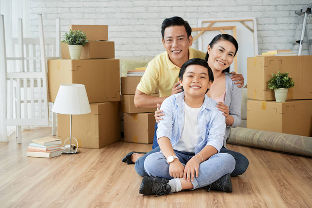 Adorable Asian family in new apartment with boxes  - Photo, Image