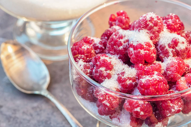 Glass of fresh raspberries sprinkled with white sugar gardening gastronomy harvest - Foto, imagen