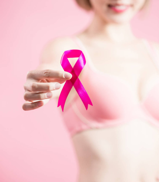 woman showing  pink ribbon with prevention breast cancer concept - Foto, imagen