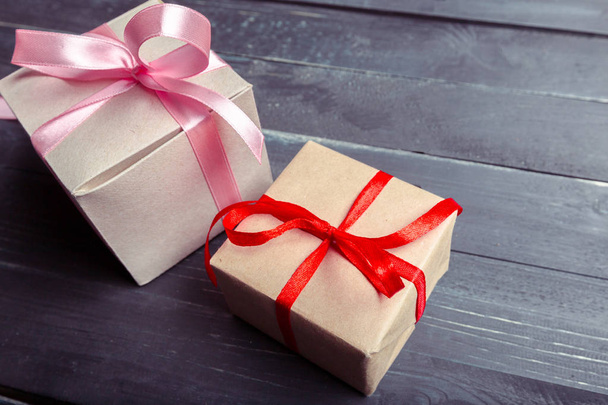 Gift boxes with pink and red ribbons on wooden background - Foto, Imagem