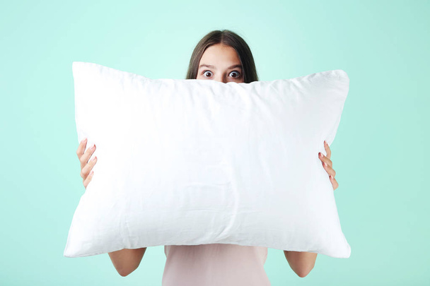 Young girl with white pillow on mint background - Fotografie, Obrázek
