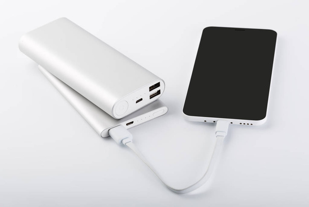 Power bank for charging mobile devices. White smart phone charger with power bank. battery bank. External battery for mobile devices. - Photo, Image