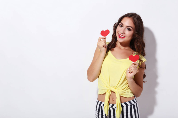 Young woman holding red paper hearts on white background - Foto, Imagem